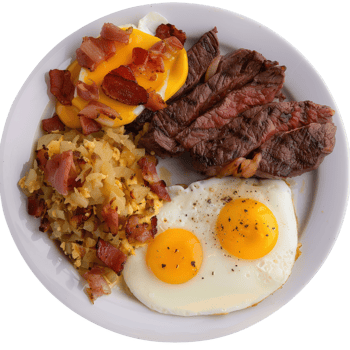 Hearty Breakfast Plate with Steak, Eggs, Potatoes, and Bacon on a White Plate png