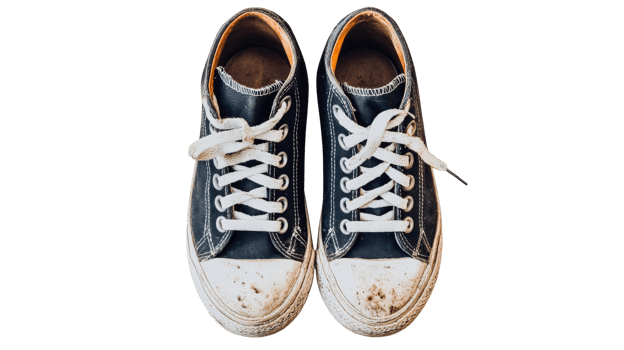 Worn black sneakers with white laces and dirty soles, cut out transparent png