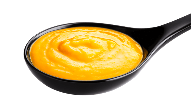 Tasty yellow sauce in black spoon, isolated on black background, cut out transparent png
