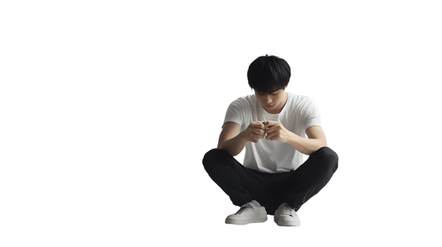 A person squatting in a casual pose wearing a white tshirt and black pants holding an object png