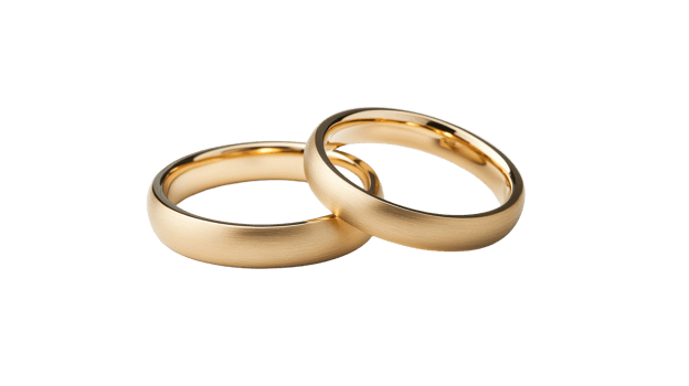 Pair of gold wedding bands close up on black background, cut out transparent png