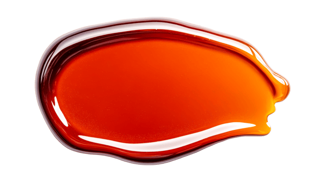 Glossy amber liquid drop isolated on black background, cut out transparent png