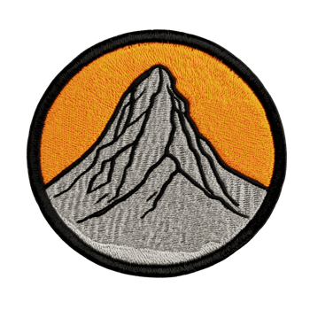 A circular embroidered patch features stylized mountain peak against orange background, symbolizing adventure and exploration. design is simple yet striking, ideal for outdoor enthusiasts png