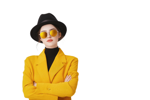 A stylish woman in yellow coat and black hat confidently poses with sunglasses, exuding modern and chic vibe. bright attire contrasts with dark accessories, creating bold fashion statement png