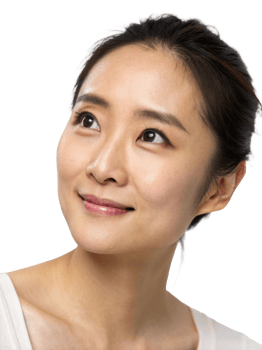 A serene young Asian woman gazes upwards with a gentle smile, showcasing natural beauty and glowing skin. png