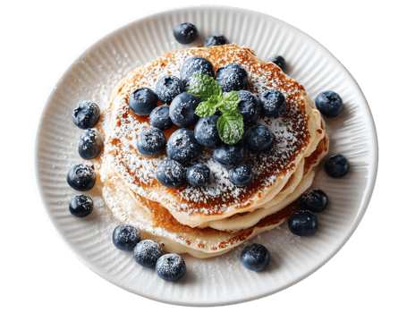 Blueberry pancakes on a plate garnished with mint and sprinkled with powdered sugar. png