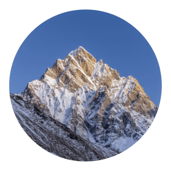 Majestic snow covered mountain peak stands tall against clear blue sky, illuminated by warm glow of sun. rugged terrain and sharp ridges create dramatic and awe inspiring landscape png