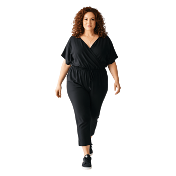 Confident Woman in Stylish Black Jumpsuit Walking with Purpose png
