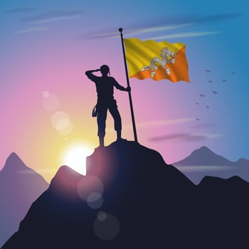 Bhutan flag raised on mountain peak with purplish yellow sunset background vector