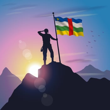 Central African Republic flag raised on mountain peak with purplish yellow sunset background vector