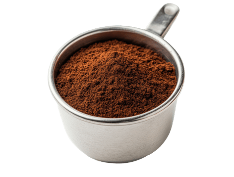 Freshly ground coffee in a stainless steel measuring cup for brewing png