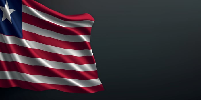 Liberia national flag waving on dark background vector
