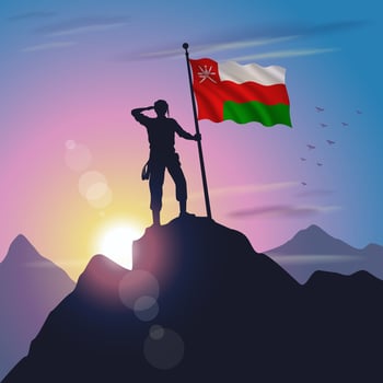 Oman flag raised on mountain peak with purplish yellow sunset background vector