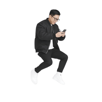 Person in black jacket and white sneakers is joyfully jumping while looking at smartphone. background is transparent, highlighting dynamic pose and casual attire png