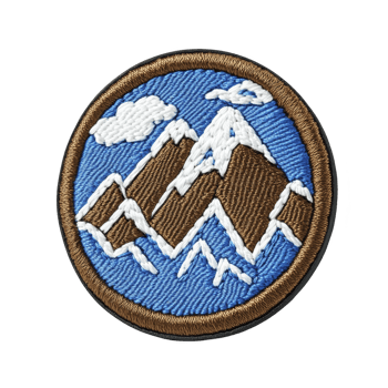 This shows round embroidered patch featuring mountain landscape with snow capped peaks and cloud against blue background. patch is bordered in brown png
