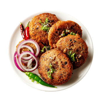 Delicious fried patties served on a plate with red onions green chilies and herbs png