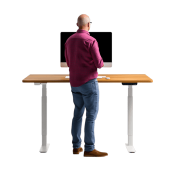 Man in Checkered Shirt Standing at Modern Adjustable Desk Working Project png