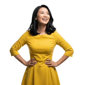 A cheerful asian woman in a vibrant yellow dress stands confidently with hands on hips, smiling brightly and looking upward. png
