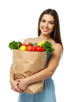Young caucasian female holding grocery bag with fresh vegetables and fruits. png